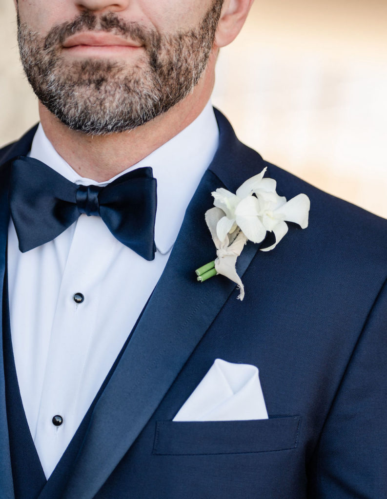 Groom boutonniere with delicate white orchids.