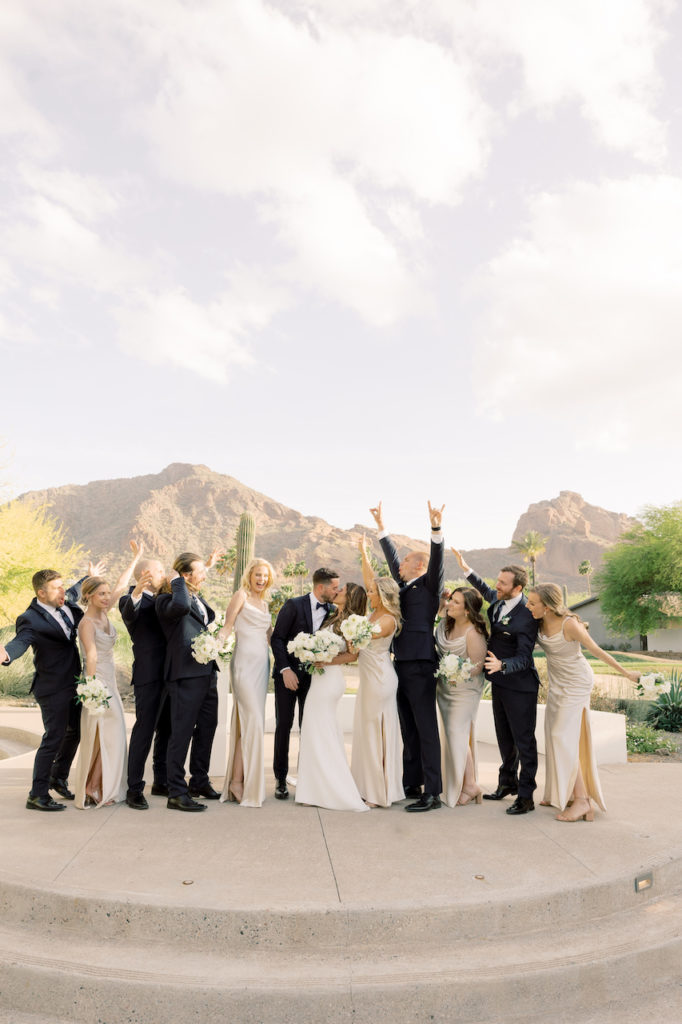 Wedding party celebrating with bride and groom on outdoor cement platform.