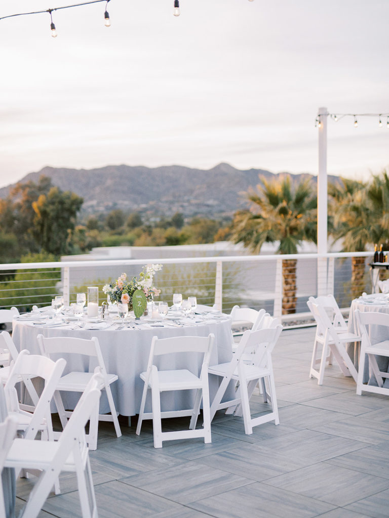 Mountain Shadows resort rooftop wedding reception with round tables, white chairs, and white linens.