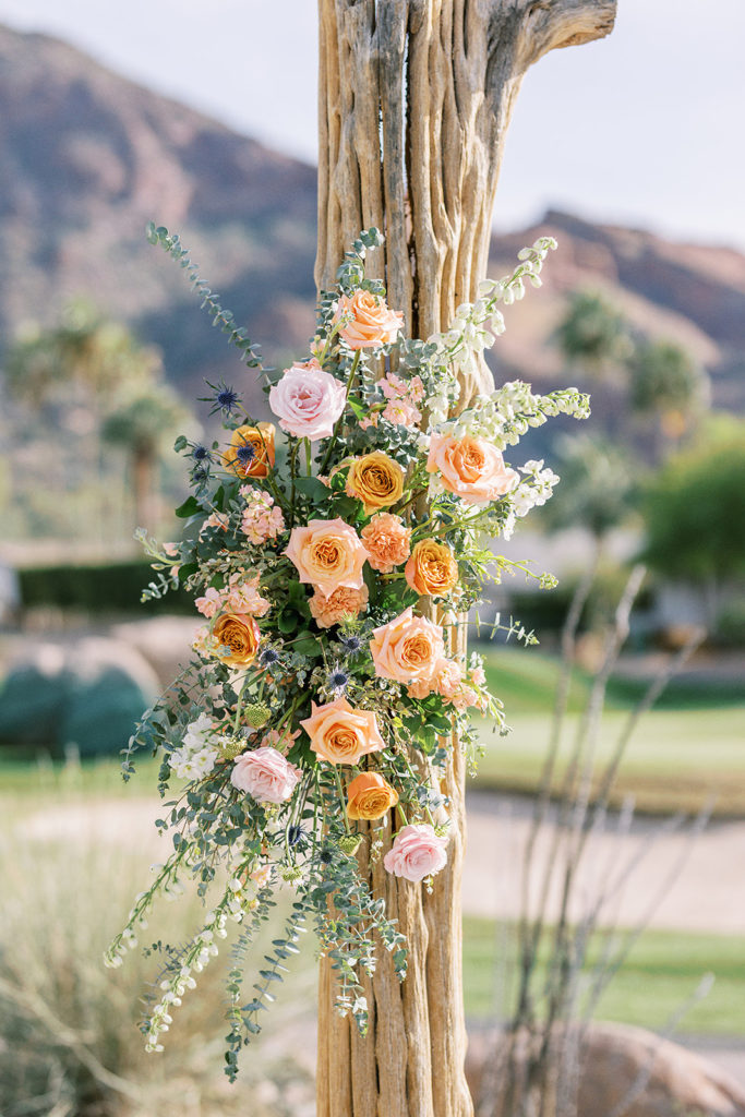 Floral installation on saguaro cactus ribs at wedding ceremony.