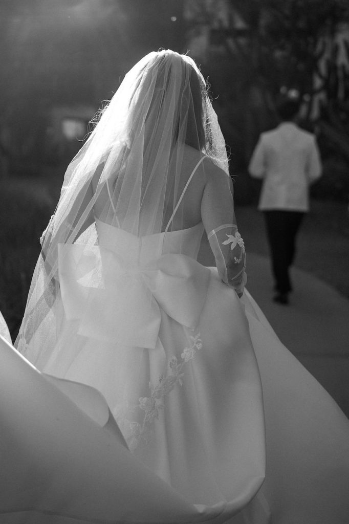 Back of wedding dress detail with long veil and big bow.
