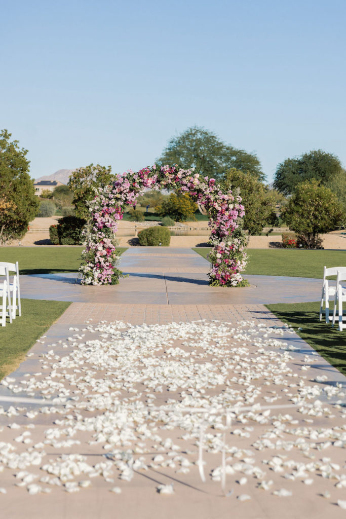Wedding ceremony outside at JW Marriott with floral petal lined aisle.