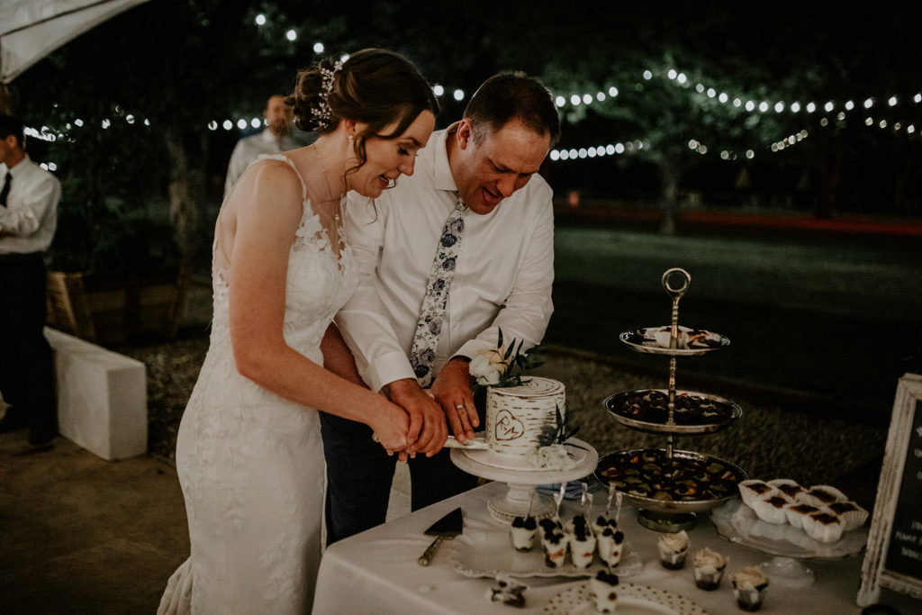 Bride and groom cutting wedding cake.