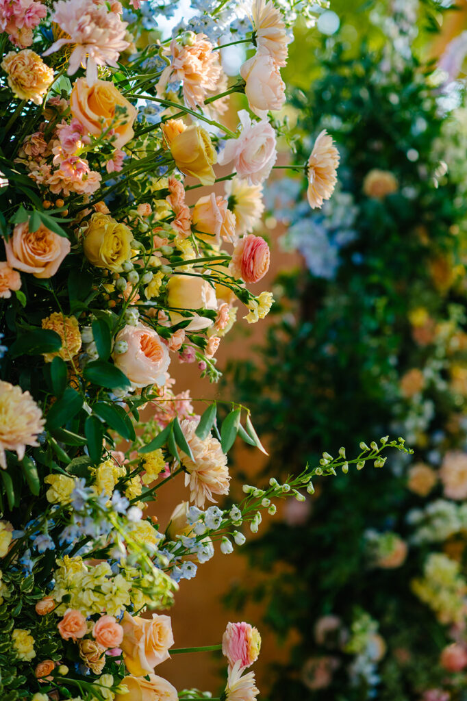 Close of up wedding ceremony floral column flowers in pink, yellow, peach colors.