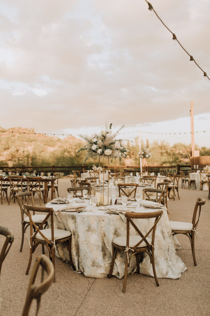 Outdoor wedding reception at Camelback Inn with round tables and tall table centerpieces.