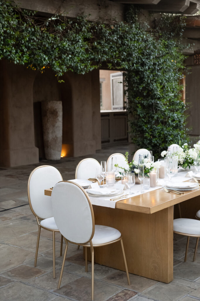 Long outdoor reception tables with candle and flower centerpieces down middle.