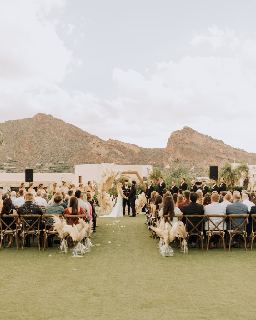 Outdoor wedding reception at Camelback Inn with desert landscape and mountains in setting and pampas floral decor.