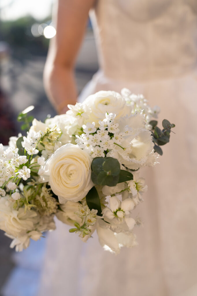 Bridal bouquet of white flowers and greenery.