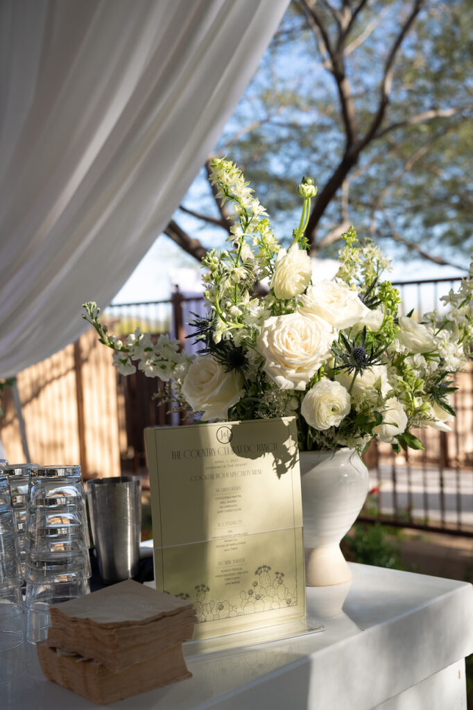 Bar floral arrangements of white flowers and greenery.