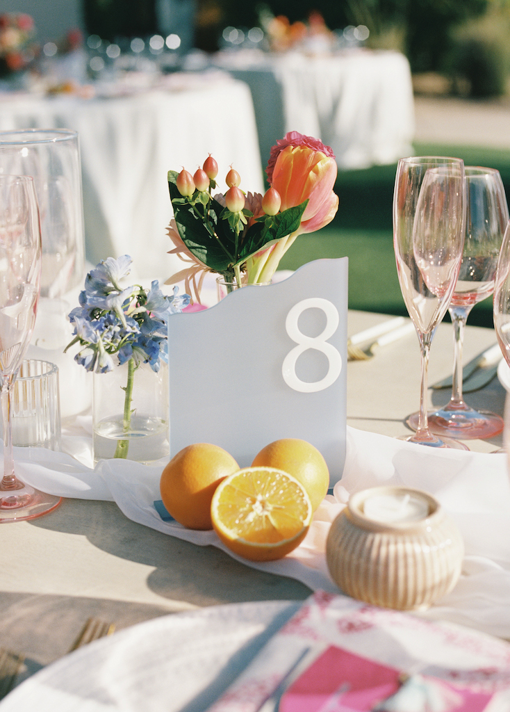 Glazed glass table number at wedding reception with cirus and bud vase flroal.