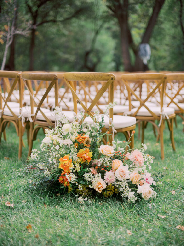 Outdoor wedding ceremony ground floral arrangement.