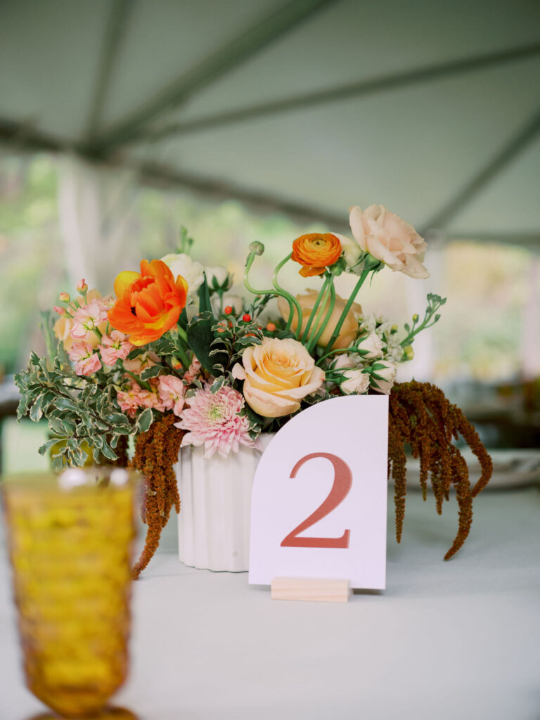 Organic floral centerpiece at wedding reception with table number.