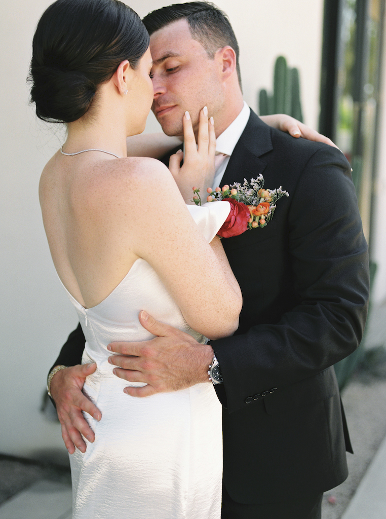 Bride and groom embracing romantically.