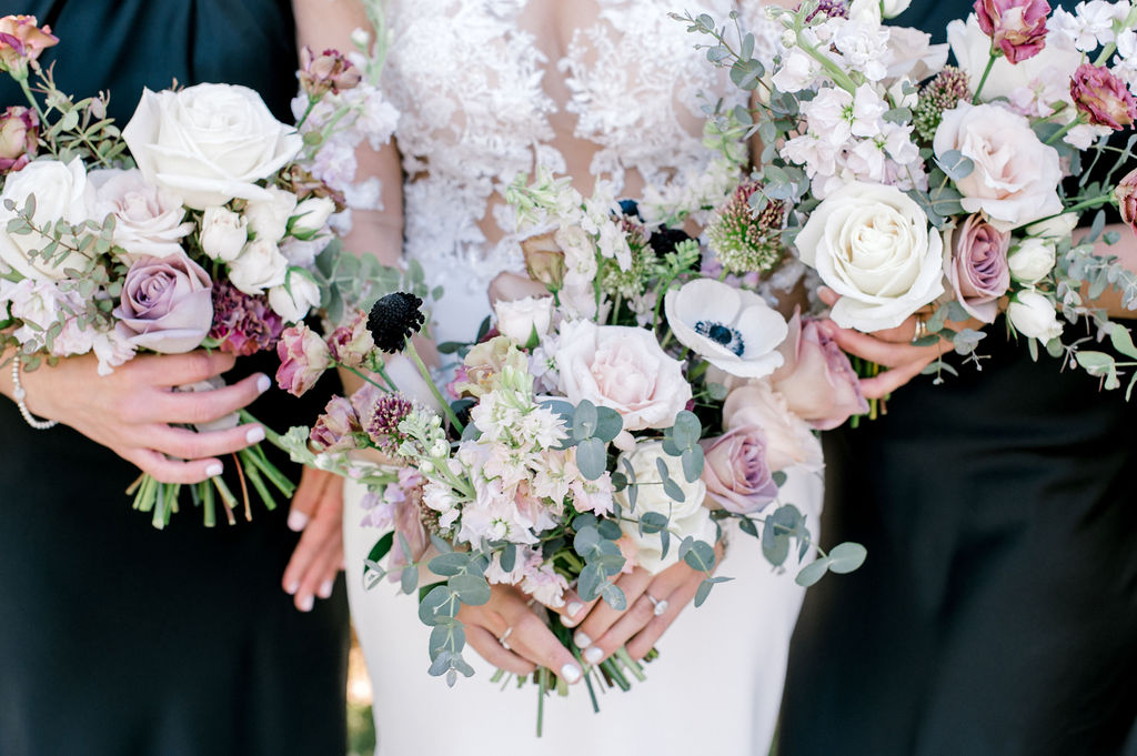 Bridal bouquet full of white, pink, and mauve flowers and eucalyptus greenery.