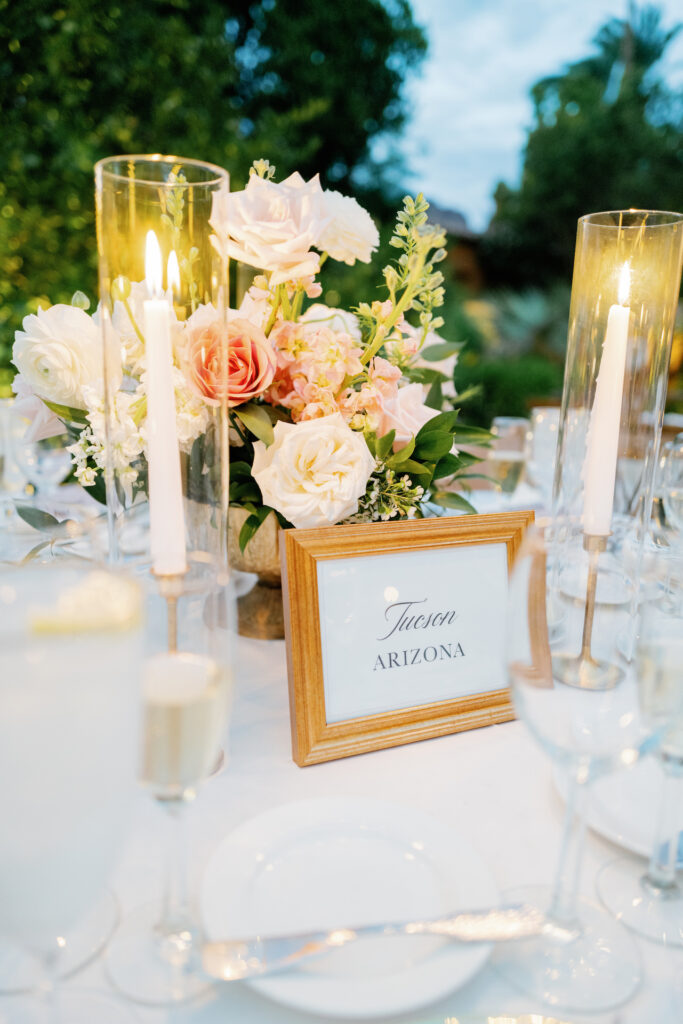 Wedding reception table with candles and floral centerpiece.
