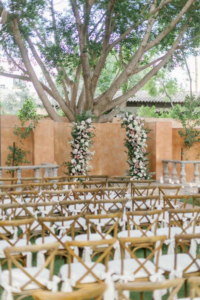 Wedding ceremony floral columns of greenery and flowers.