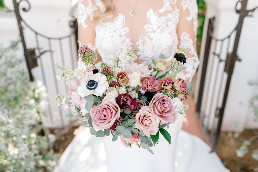 Close image of bridal bouquet including mauve, pink and white flowers.