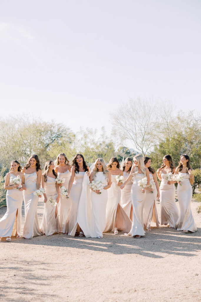 Ladies holding bouquets walking with desert trees around them.
