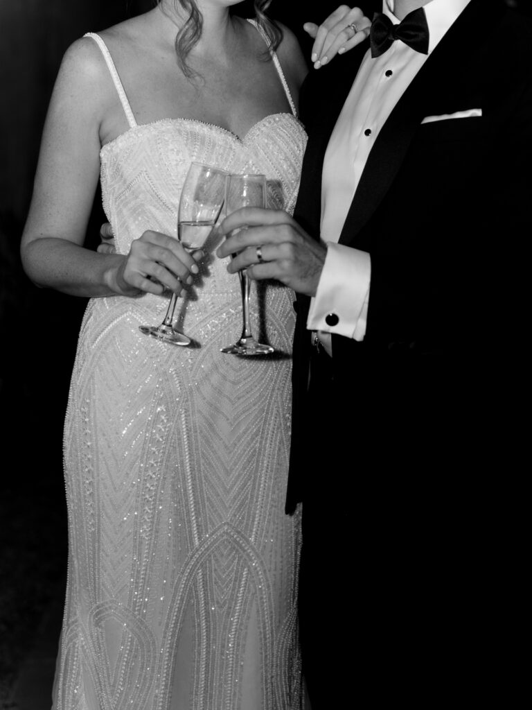 Bride and groom toasting champagne glasses.