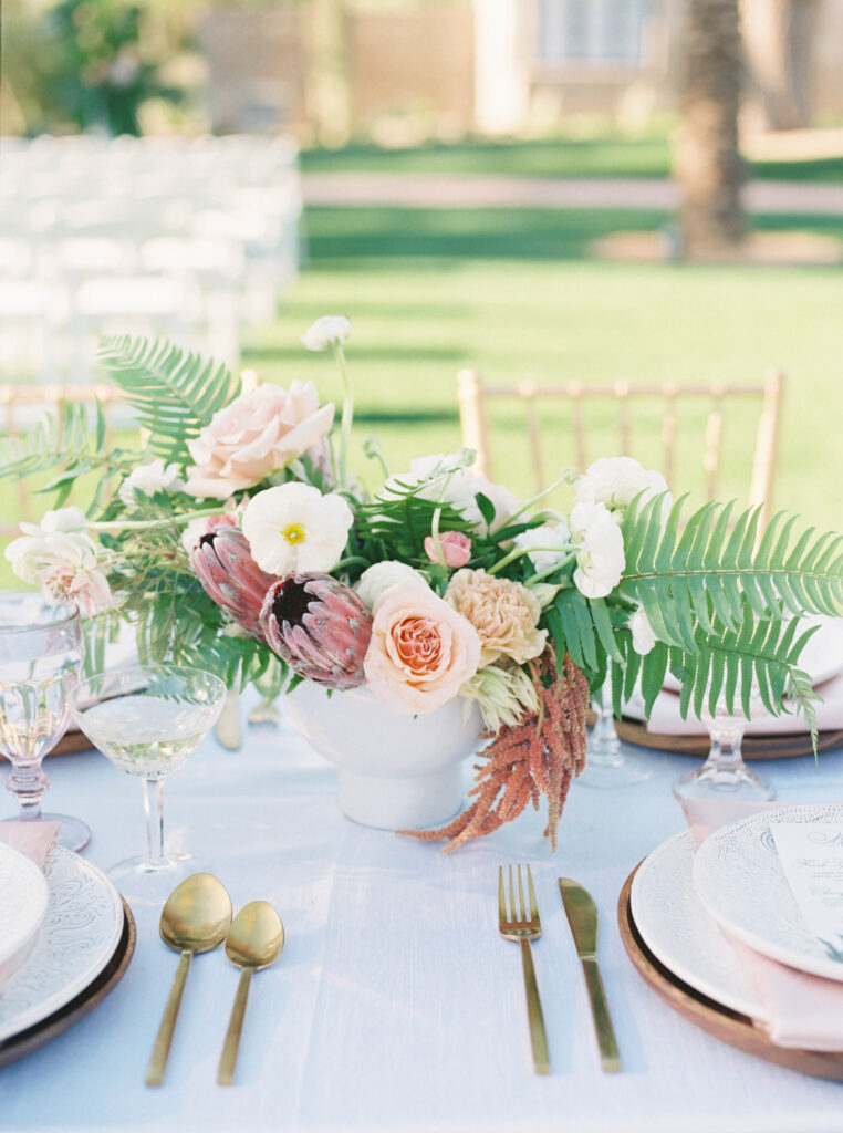 Tropical pink floral centerpiece at wedding reception table.