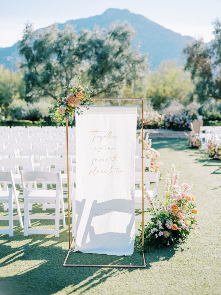 Wedding ceremony welcome sign of hanging white fabric.