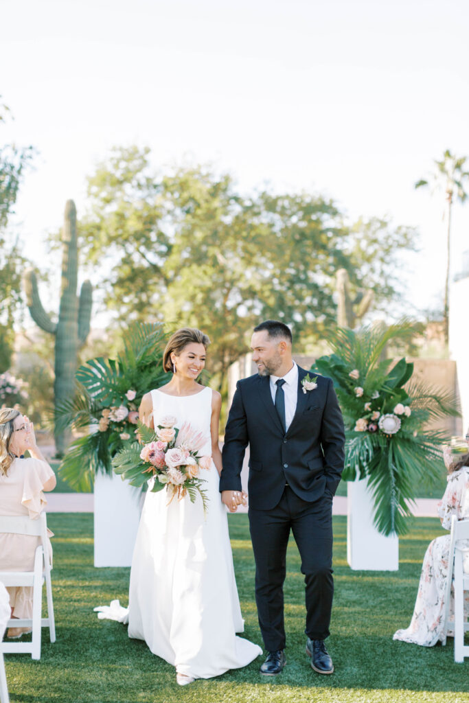 Arizona Biltmore outdoor wedding ceremony with bride and groom walking down aisle.