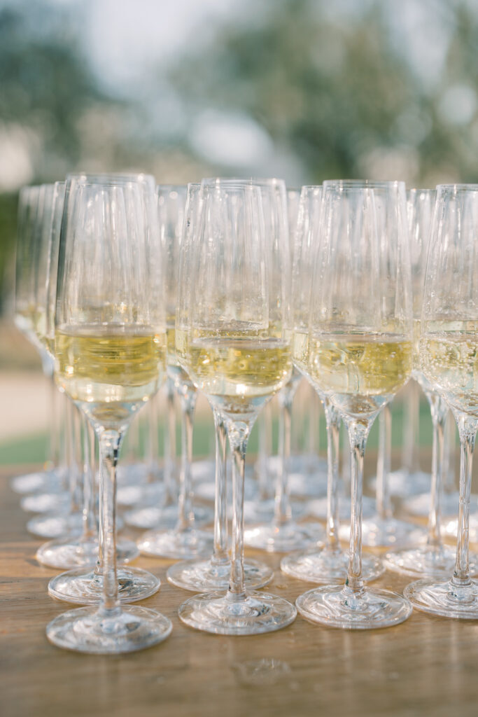 Champagne glasses in rows and columns with champagne in them.