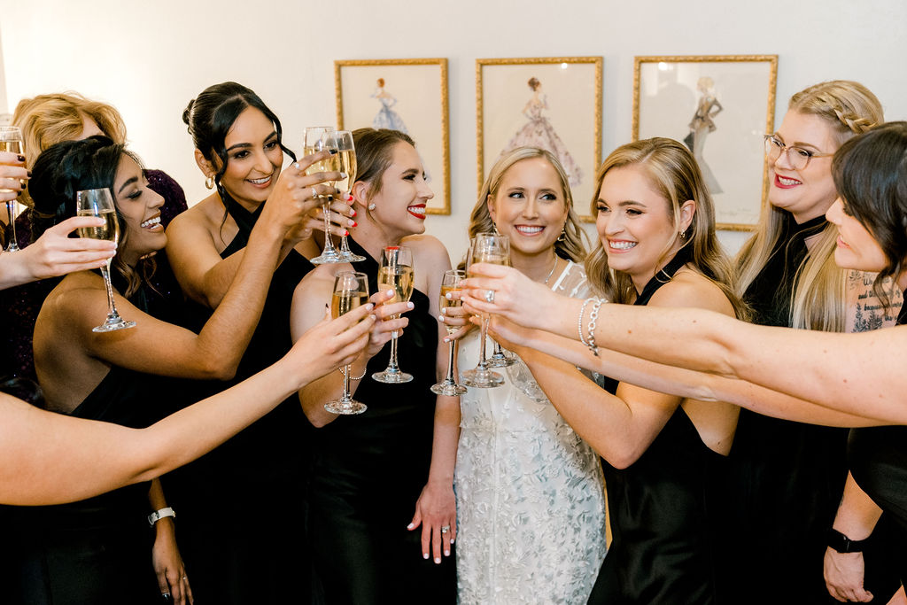 Bride toasting with bridesmaids with champagne glasses.