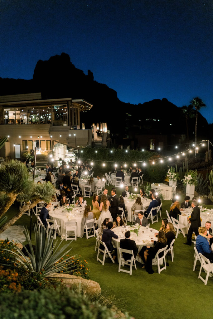 Outdoor wedding reception at night at Sanctuary resort with round tables.