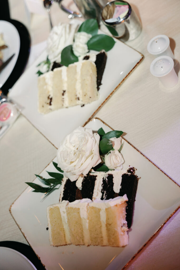 Wedding cake slices of white and chocolate cake on two plates.