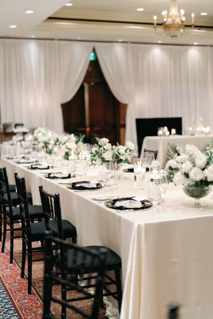 Wedding reception long table with white and blush flower centerpieces.
