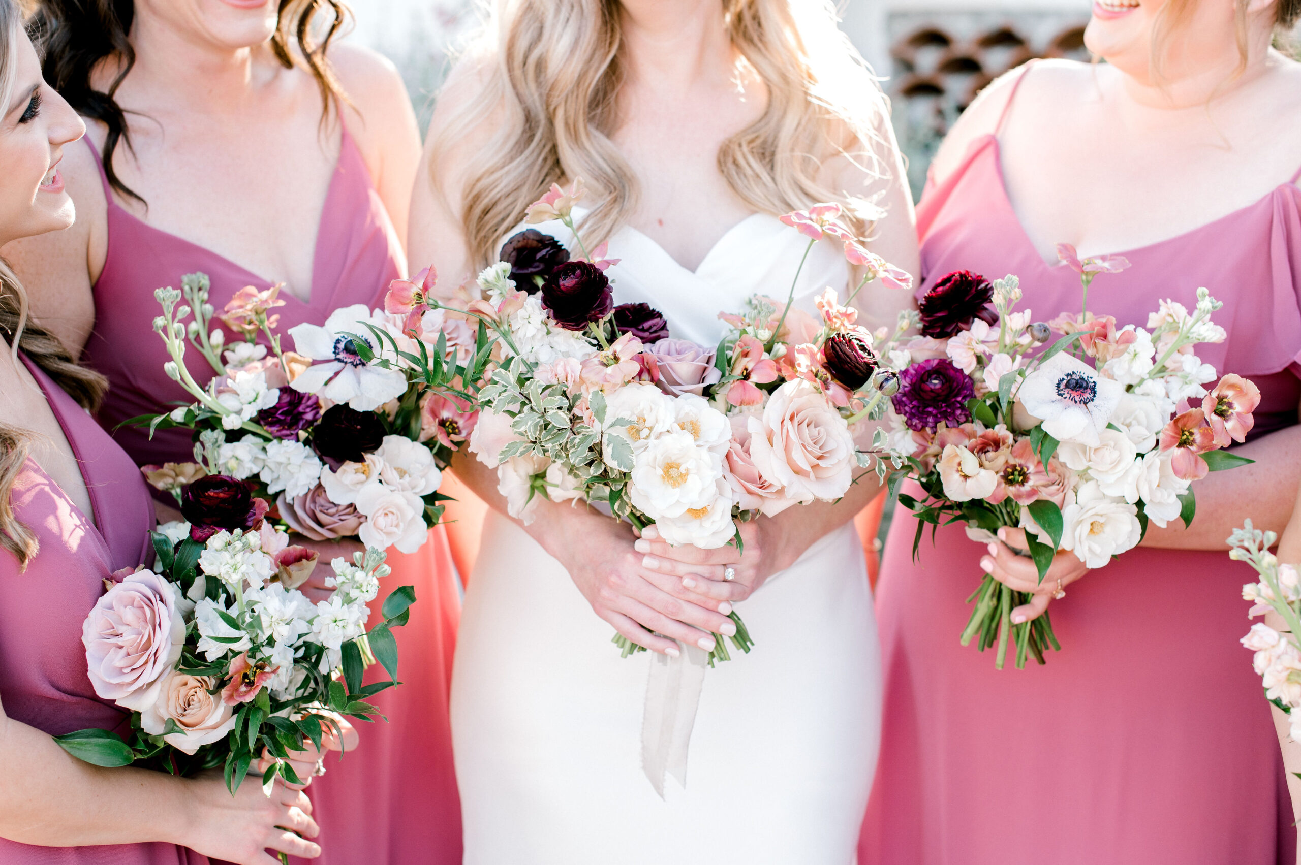 Bridal bouquet and bridesmaid bouquets of white, pink, blush, mauve, and burgundy flowers.