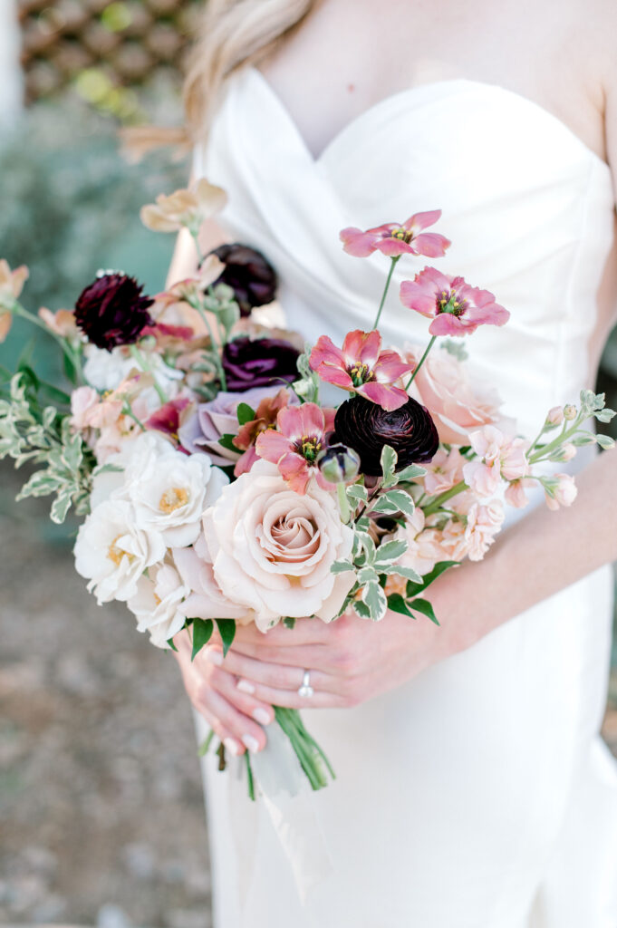 Bridal bouquet of white, pink, blush, mauve, and burgundy flowers.
