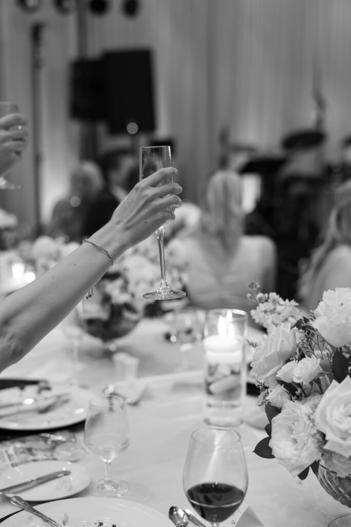 Person toasting with champagne glass at wedding reception.