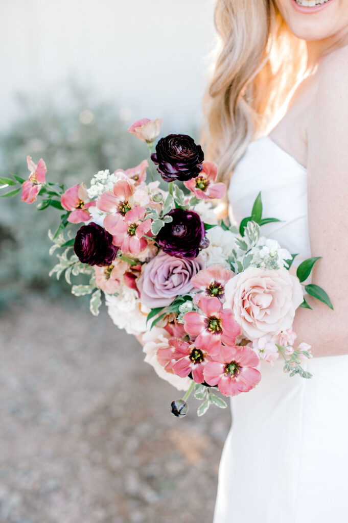 Bridal bouquet of white, pink, blush, mauve, and burgundy flowers.