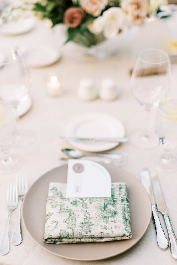Wedding reception place setting taupe plate and paisley napkin.