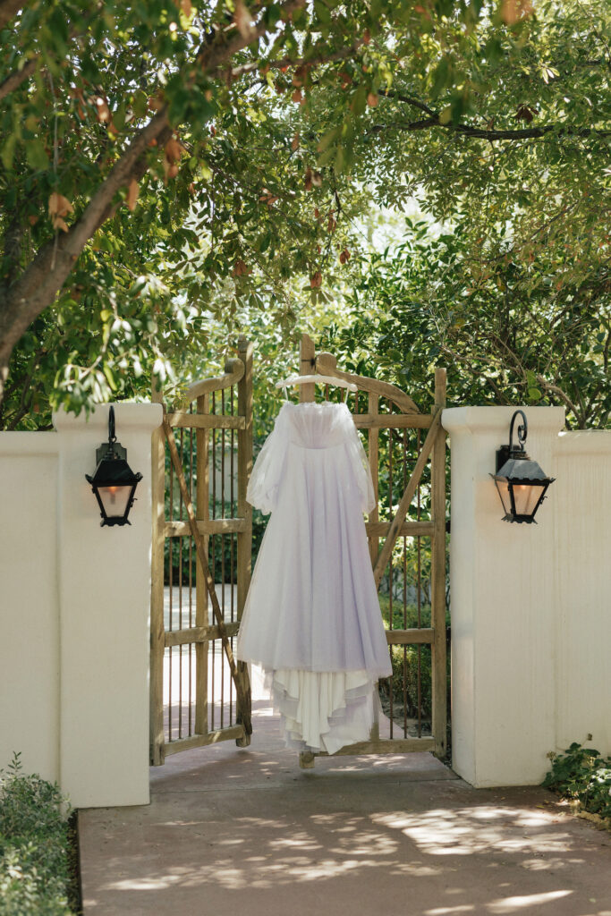 Custom lavender wedding gown handing on wooden gate at El Chorro.