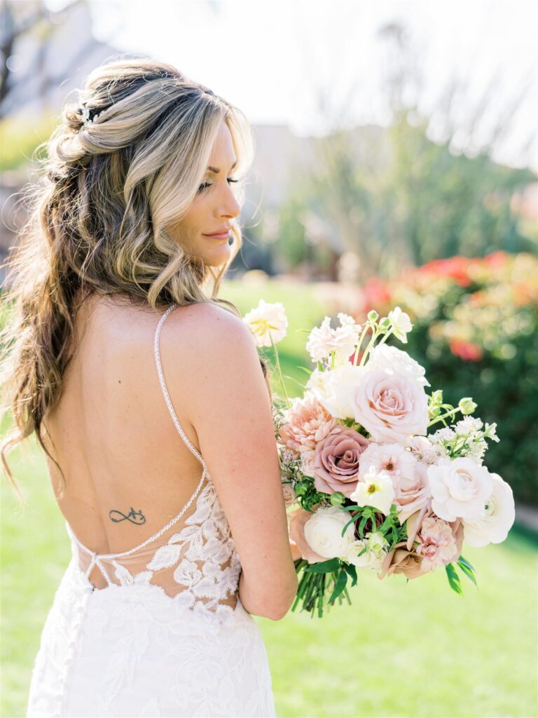 Bride looking over shoulder while holding bridal bouquet.