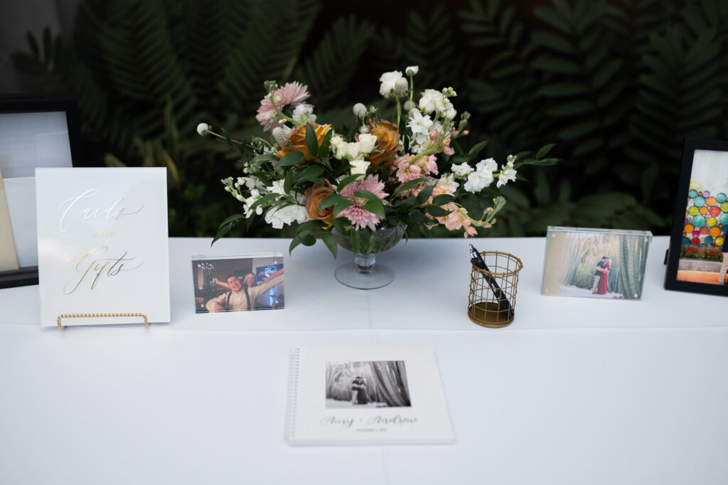 Welcome table with floral arrangement and guestbook.