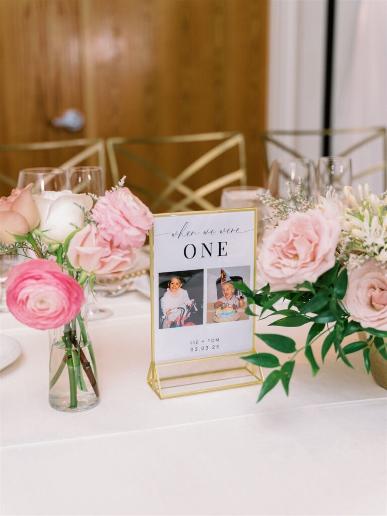 Custom table number at wedding with baby pictures of bride and groom.