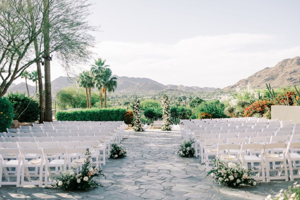 Outdoor wedding ceremony at Sanctuary Resort with floral pillars in altar space and aisle ground floral.