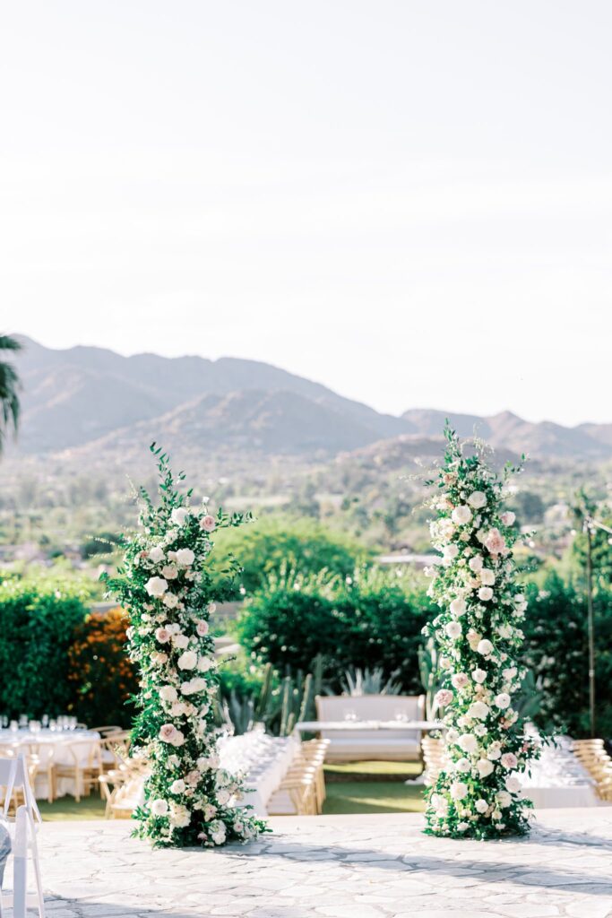 Outdoor wedding ceremony at Sanctuary Resort with floral pillars in altar space.