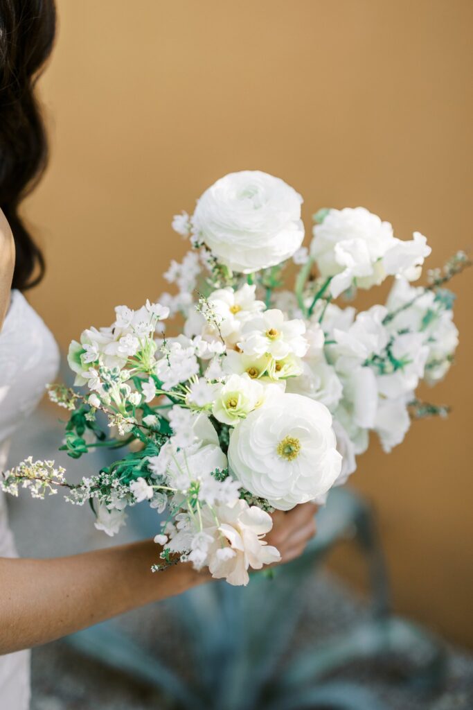Dainty white flowers bridal bouquet with hint of blush and yellow centers.