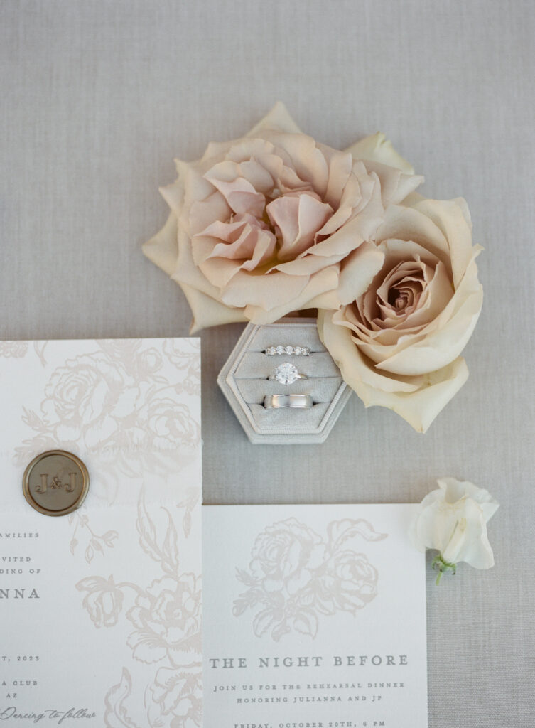 Wedding ring and invitation details with blush pink roses.