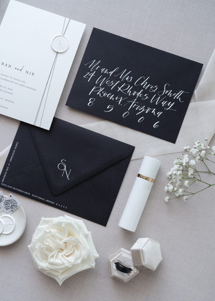 White and black invitation suite with white roses and baby's breath details.