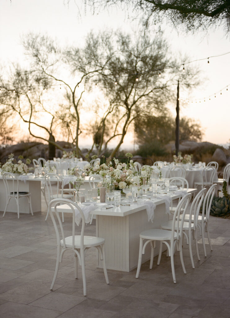 Outdoor wedding reception space at Estancia with white tables and white and blush floral.