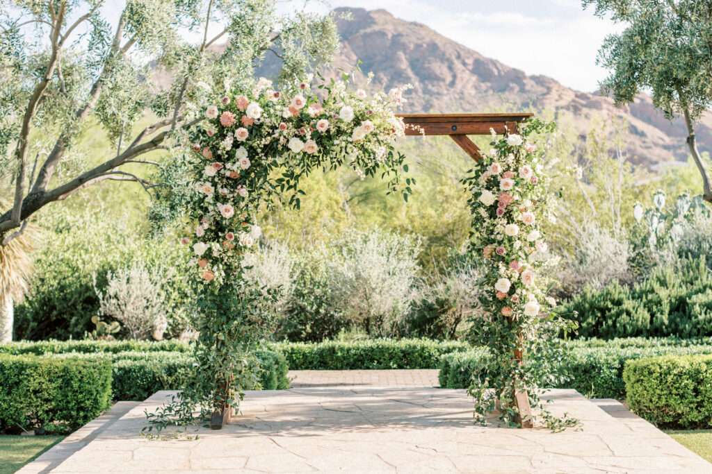 Outdoor wedding ceremony arch with floral installation.