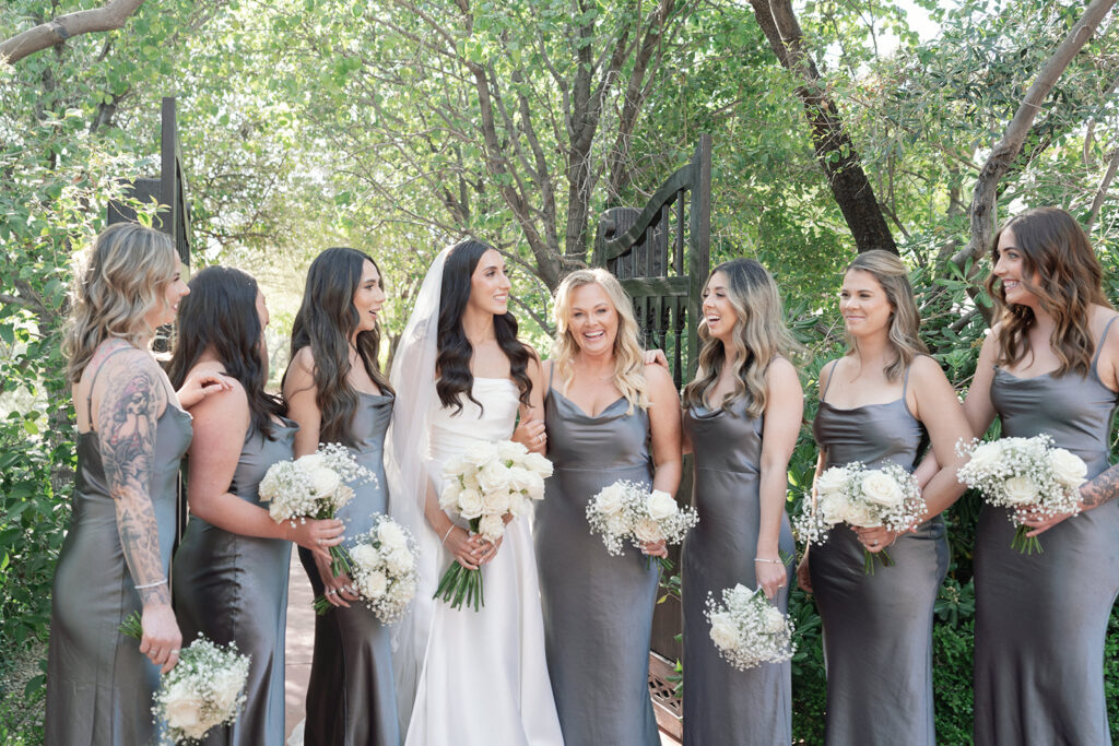 Bride standing in a line with bridesmaids wearing slate gray matching dresses.