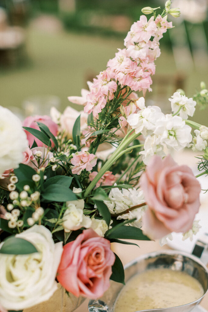Wedding reception floral centerpiece details of pink and white flowers with greenery.