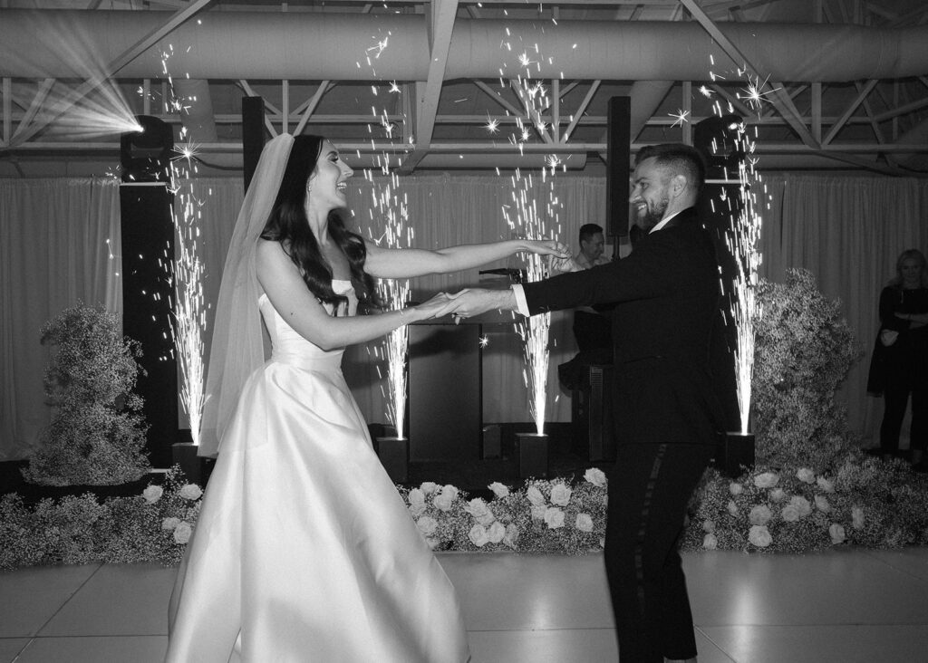 Bride and groom dancing on indoor dance floor at wedding reception.